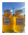 Two jars of Taylor Raw Sainfoin Honey with a clear blue sky background.